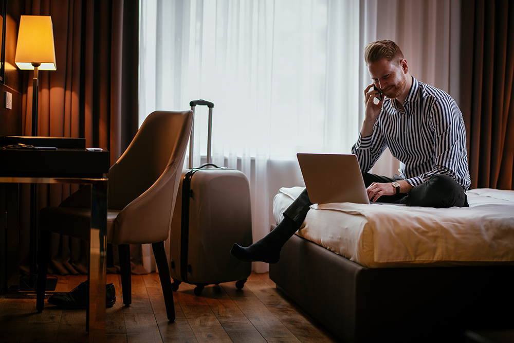 Man working on laptop in hotel with wireless connectivity services for property management installed by RFE Communications