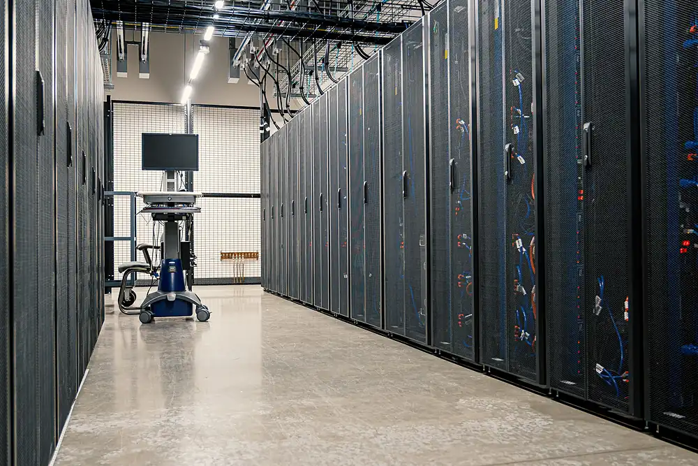 errcs-data-center Rows of server racks in a data center aisle with overhead cable trays